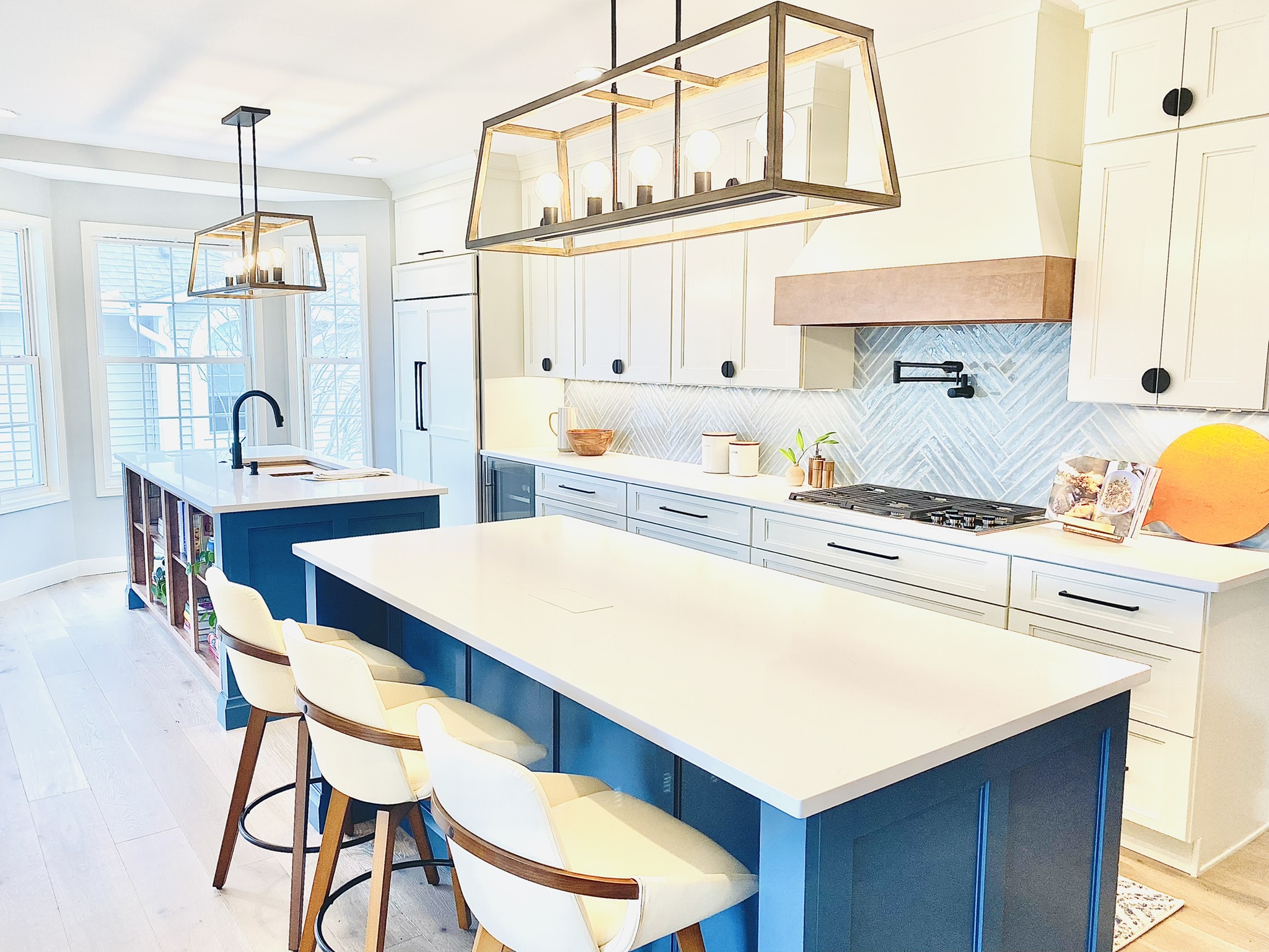 A newly renovated kitchen with white cabinets and green islands sold from a cabinetry supply business.
