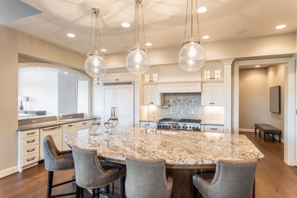 Beautiful white open concept kitchen with pendant lighting and white cabinetry.